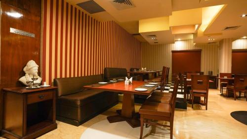 a restaurant with a couch and a table and chairs at MGM Mark Whitefield in Bengaluru