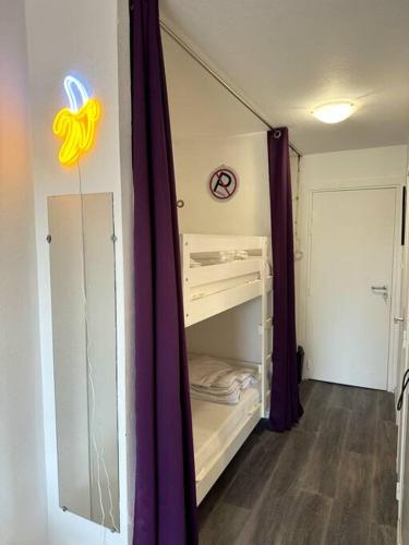Cette chambre dispose d'un dressing avec des rideaux violets. dans l'établissement Appartement Cap d'Agde centre port, au Cap d'Agde