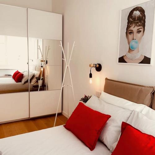 a bedroom with a bed with red pillows and a mirror at City center, all around you in Turin