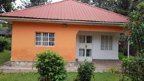 a small orange house with a red roof at Mutolere Coffee Pot Guest Houses in Kisoro