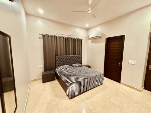 a bedroom with a bed in a room with a door at Private 3 BHK - Woodstock Villa Amritsar in Amritsar