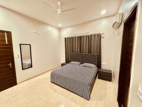 a bedroom with a bed and a mirror at Private 3 BHK - Woodstock Villa Amritsar in Amritsar
