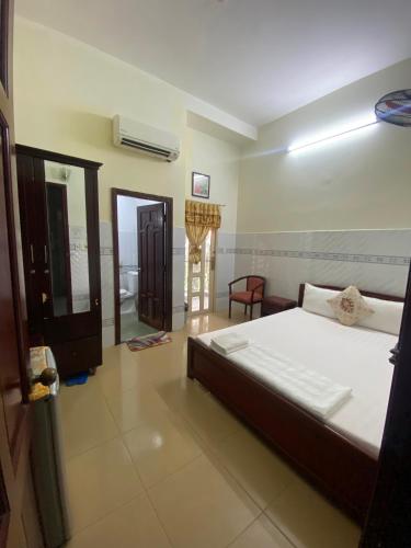 a bedroom with a bed and a living room at Khách sạn Kim Phụng Ngân in Can Tho