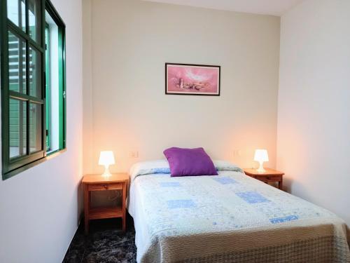 - une chambre avec un lit et deux lampes sur deux tables dans l'établissement Bonita casa cerca de la playa - Chalet Eras Costeras, à Las Eras