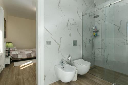 ein Badezimmer mit Toilette und Glasdusche in der Unterkunft Emi's Villa in Golem