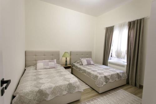 ein Schlafzimmer mit zwei Betten und einem Fenster in der Unterkunft Emi's Villa in Golem