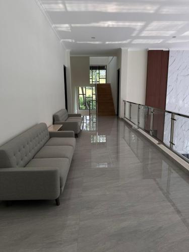 a living room with a couch and a staircase at Aldeoz Villa Sentul in Babakan Madang