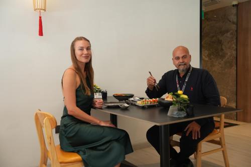 a man and a woman sitting at a table with food at AG Hotel in Abu Dhabi