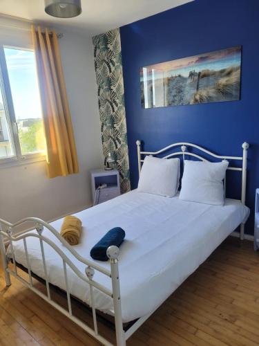 a bedroom with a white bed with a blue wall at Spacieux T5 confort 9 pers in Angers