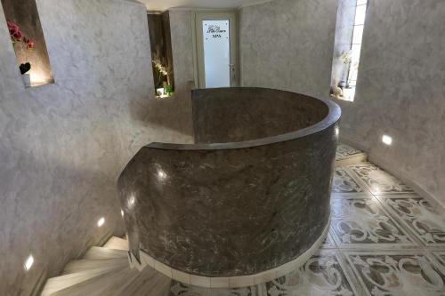 a bathroom with a large marble tub in a room at La Perla Bianca Luxury Spa by Perle di Puglia in Oria