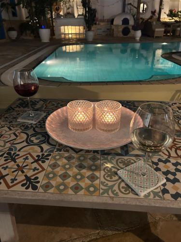 a table with two glasses of wine and a plate of food at Little Stone House in Lymbia