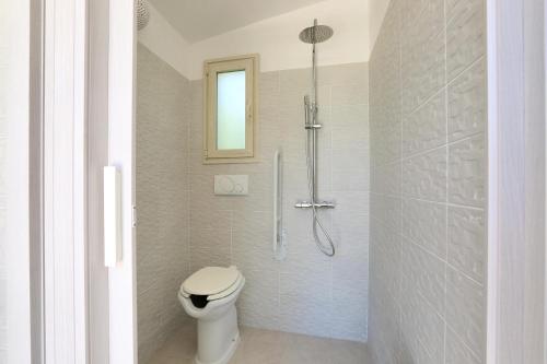 a bathroom with a shower with a toilet in it at La Perla Bianca Luxury Spa by Perle di Puglia in Oria