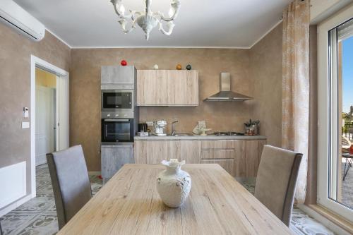 a kitchen with a wooden table with chairs and a vase on it at La Perla Bianca Luxury Spa by Perle di Puglia in Oria