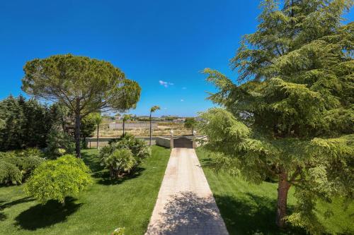 a walkway in a park with a tree at La Perla Bianca Luxury Spa by Perle di Puglia in Oria