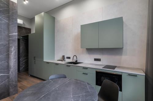 a kitchen with a table and a white cabinet at Apartments in Vilnius in Vilnius