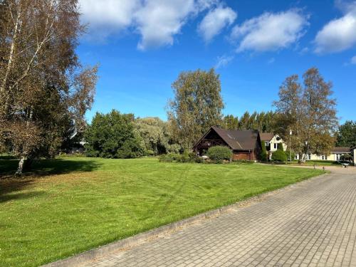 a grassy field with a house in the background at Brīvdienu māja Mulki in Ģipka
