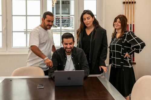 Un groupe de personnes autour d'une table avec un ordinateur portable dans l'établissement WS Nation - Reuilly, à Paris