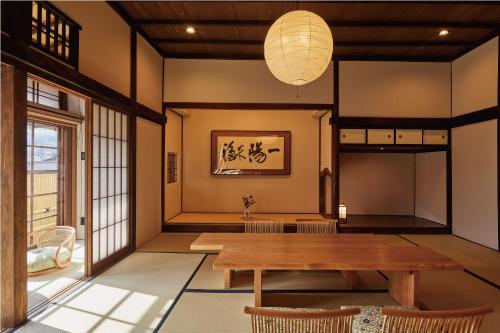 a dining room with a wooden table and chairs at Tomonoura Shiomachi Hotel in Fukuyama
