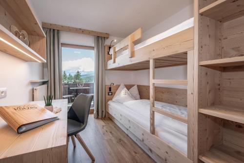 een slaapkamer met een stapelbed en een bureau bij Haus Pötzes in Castelrotto