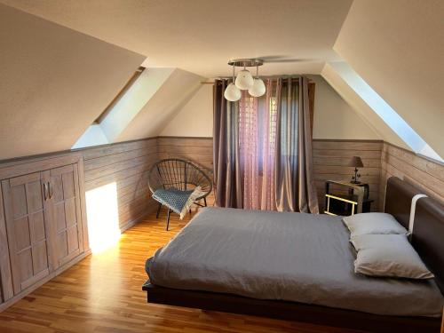 a bedroom with a bed and a chair at Brīvdienu māja Mulki in Ģipka