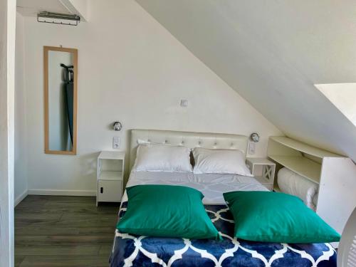 - une chambre avec un lit doté d'oreillers verts et blancs dans l'établissement Appartement en duplex proche gare d'Amiens, à Amiens