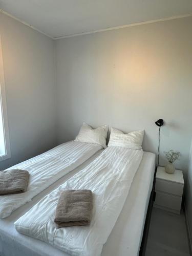 a large white bed with two towels on it at Apartment Solsiden Trondheim in Trondheim