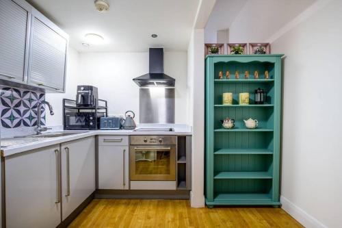 a kitchen with a green cabinet in a kitchen at Charming Apartment in Liverpool City Centre - Peaceful Sleep! in Liverpool