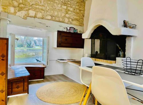 a kitchen with a table and chairs and a fireplace at Le Quai 2, ancien Moulin au Bord de la Charente - Charme et Sérénité à Jarnac in Jarnac
