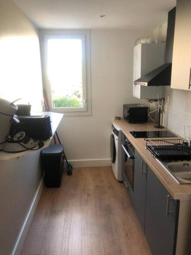 une petite cuisine avec un évier et une fenêtre dans l'établissement Le Morison Bonnefoy - T2 - Parking - Proche Gare, à Toulouse