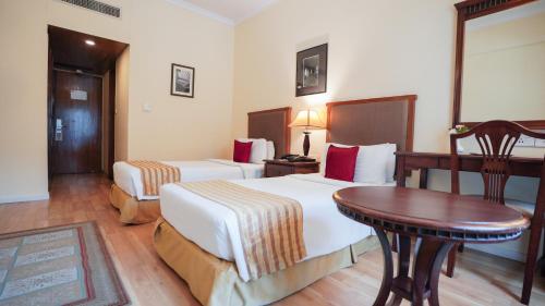 a hotel room with two beds and a table at MGM Mark Whitefield in Bengaluru