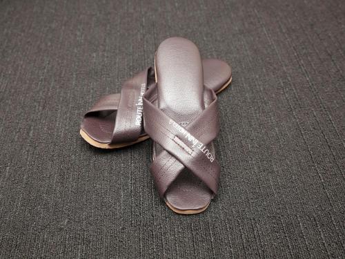 a pair of brown shoes sitting on a carpet at Hotel Route Inn Suzaka in Suzaka