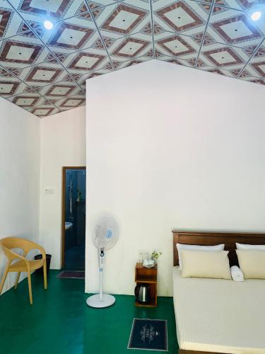 a living room with a couch and a fan at Cinty Guest House in Dambulla