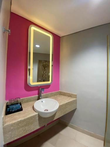 a bathroom with a sink and a mirror at Shakti Hotel Bandung in Bandung