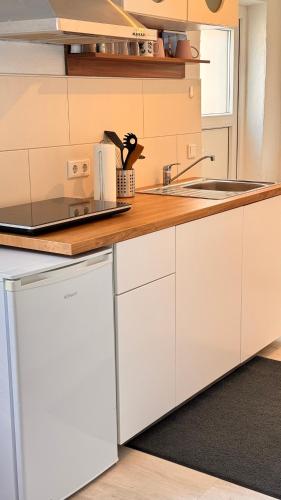 a kitchen with white cabinets and a counter top at Apartment Fabio in Borkum