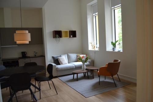 a living room with a couch and a table and chairs at Hotel Lille Nyhavn in Skanderborg