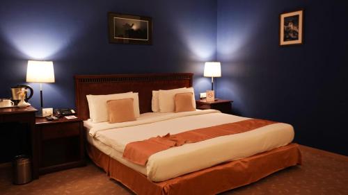 a bedroom with a large bed with two tables and two lamps at MGM Mark Whitefield in Bengaluru
