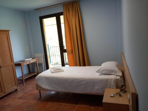 a bedroom with a white bed and a window at Agriturismo La Bella Manza in Lurate Caccivio