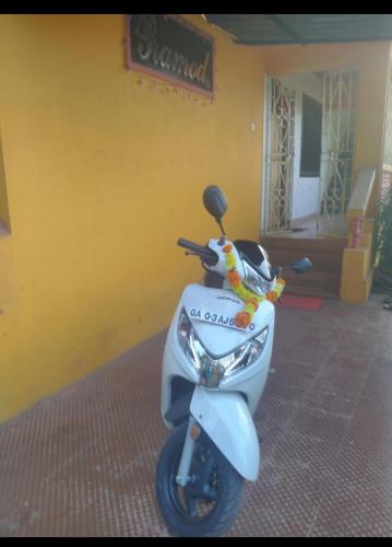 a scooter parked in front of a yellow wall at Pramod Guesthouse in Guirim