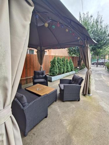 a patio with a table and chairs and an umbrella at D&D Busteni in Buşteni
