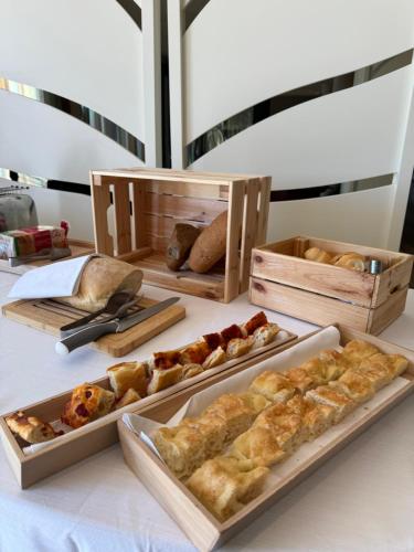 a table with several trays of bread and pastries at Grand Hotel Forlì in Forlì