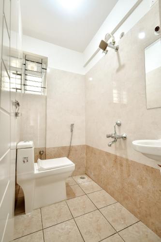 a bathroom with a toilet and a sink at Namma HomeSlice, Balcony Rooms in Brookefield in Bengaluru