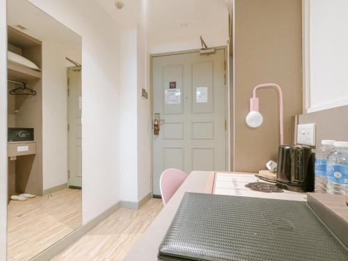 a kitchen with a table and a pink lamp at A Hotel Joo Chiat in Singapore