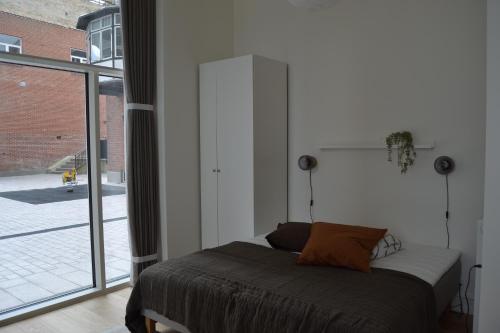a bedroom with a bed and a large window at Hotel Lille Nyhavn in Skanderborg