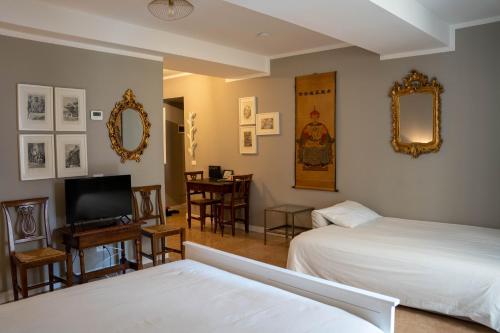 a bedroom with two beds and a television and a table at Canard Suite in Bologna
