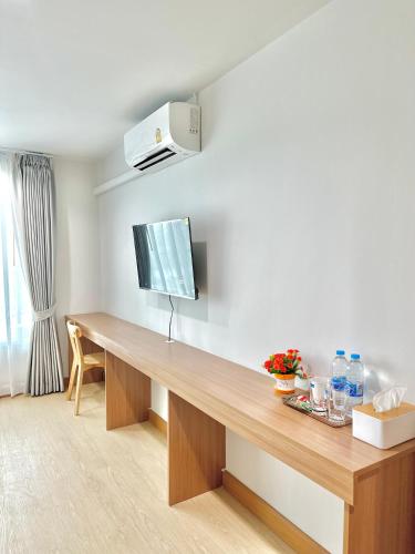 a room with a wooden desk with a tv on the wall at Pingchan Hotel Soidao in Ban Phra Trong