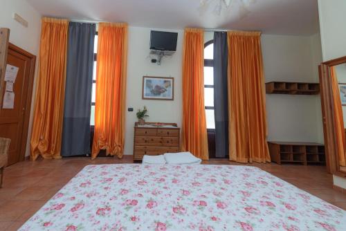 a bedroom with a large bed and orange curtains at Agriturismo Fiori d'Arancio in Palagiano