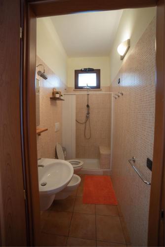 a bathroom with a sink and a toilet with a window at Agriturismo Fiori d'Arancio in Palagiano