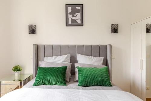 a bedroom with a bed with green pillows at Appartement moderne entier Paris-le Bourget et CDG in Le Bourget