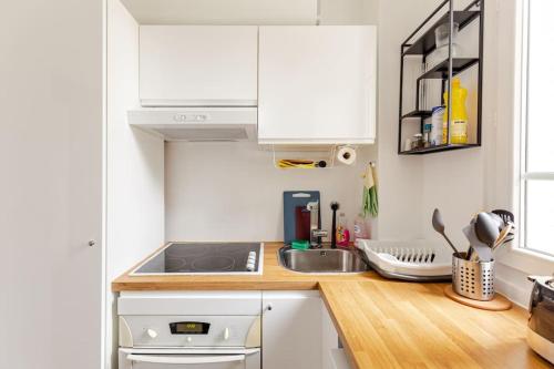 a kitchen with white cabinets and a sink at Appartement moderne entier Paris-le Bourget et CDG in Le Bourget
