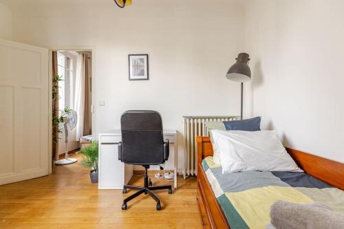 a bedroom with a bed and a desk and a chair at Appartement moderne entier Paris-le Bourget et CDG in Le Bourget
